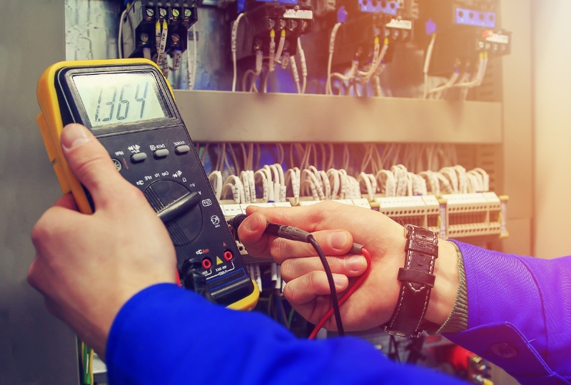 Electrician observing a reading on handheld tool